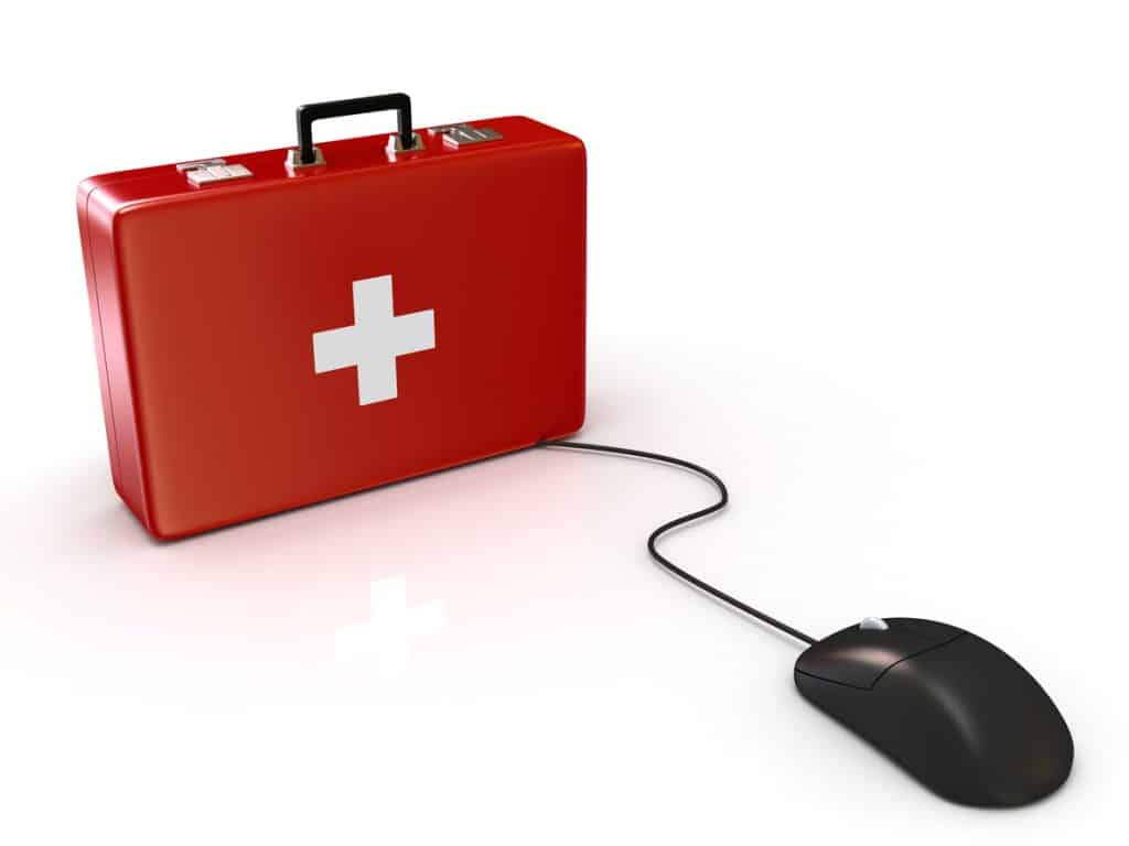 Ein roter Erste-Hilfe-Koffer mit weißem Kreuz ist per Kabel mit einer Computermaus verbunden.