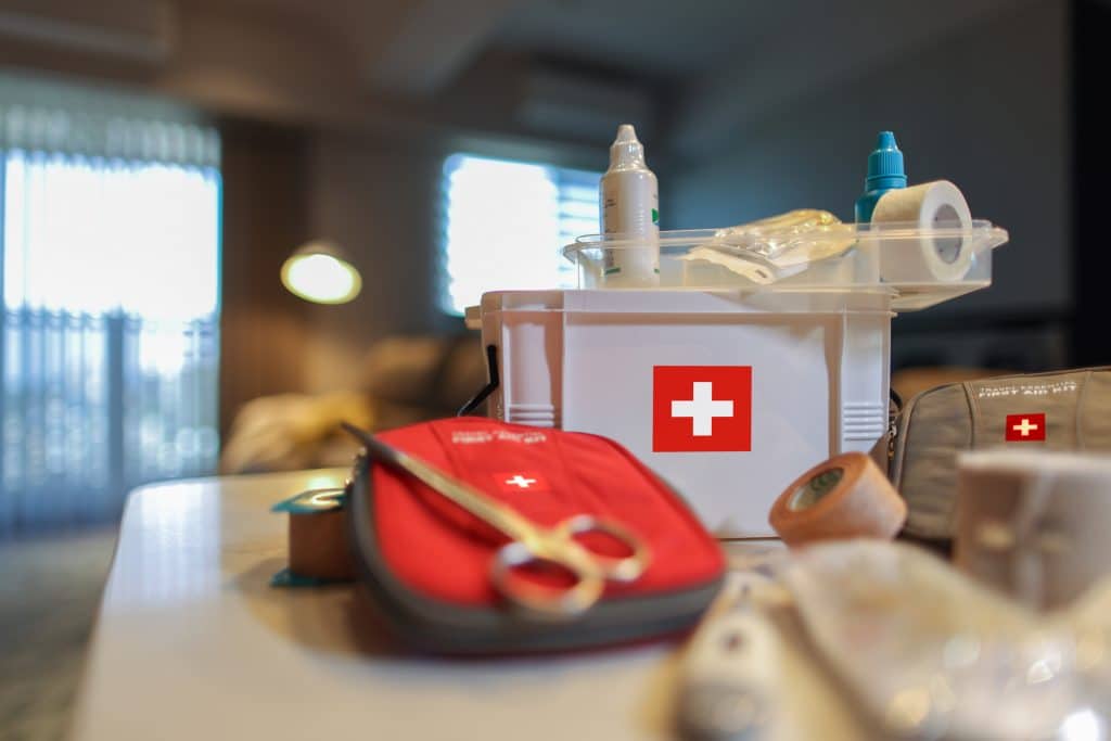 Ein vollständiges Erste-Hilfe-Set liegt ausgepackt auf einem Tisch.